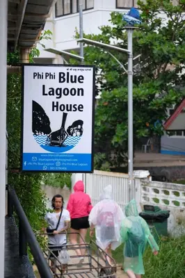 a sign for a blue lagoon house with people in plastic bags at Phi Phi Blue Lagoon in Phi Phi Don