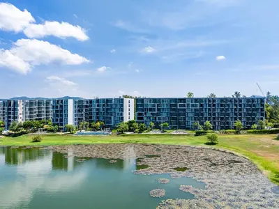 a large building next to a body of water at Laguna cassia residences in Bang Tao Beach