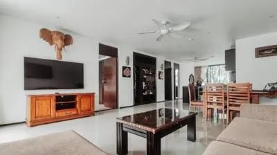 a living room with a tv and a table at Casuarina Shores Apartment - SHA Plus in Bang Tao Beach