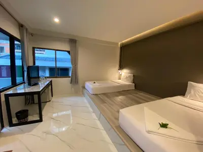 a hotel room with two beds and a desk at The dream garden in Ao Nang Beach