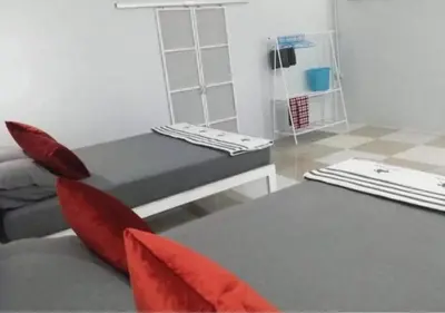 a living room with a bed and red pillows at Farm House kohyaoyai in Ko Yao Yai