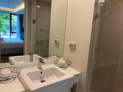 a bathroom with a sink and a shower and a mirror at The aristo-access pool room Surin beach in Phuket Town