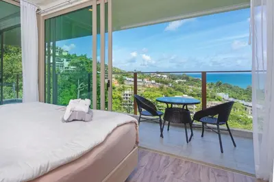 a bedroom with a bed and a view of the ocean at Oceana Sea View - Kamala Beach in Kamala Beach
