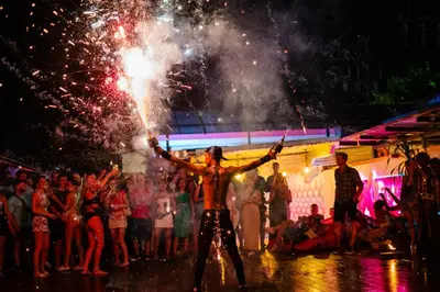 a group of people standing in the street with fireworks at Base Ao Nang Beachfront Party Hostel 18-35 Years Old Only in Ao Nang Beach