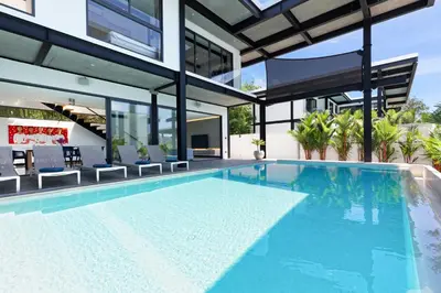 an empty swimming pool in a house at Loft Style 4BR Villa Sunset Garden 4 with 12m Salt Water Pool, near NaiHarn in Rawai Beach