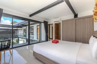 a bedroom with a large bed and a large window at Loft-Style Hyper Modern 4Br Villa Sunset garden 6 with 12x5m Salt Pool in Rawai Beach