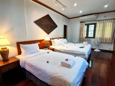 two beds in a hotel room with flowers on them at Kata Pool Villa ​No.7 in Kata Beach