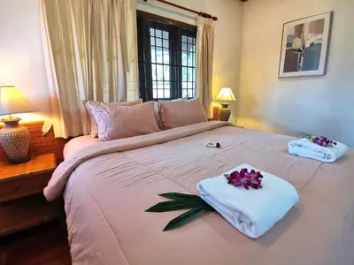 a large white bed with towels and flowers on it at Kata Pool Villa ​No.7 in Kata Beach