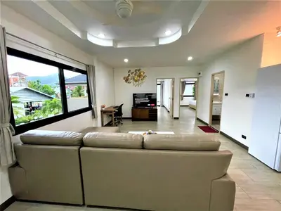 a living room with a couch and a large window at Kamala Fantasy 5 Bedroom Modern Private Pool Villa in Kamala Beach