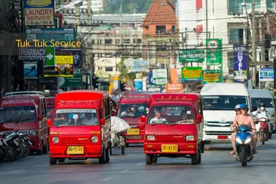 a group of red vehicles driving down a busy city street at Add Plus Hotel & SPA in Patong Beach