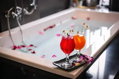 two cocktails on a tray in a bath tub at Nut & Non Pool Villa by Duangtham in Ban Khlong Haeng