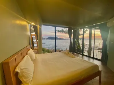 a bedroom with a bed with a view of the ocean at patong sunset villa Phuket in Patong Beach