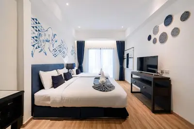 a bedroom with a large bed and a television at Sabai Hotel Aonang in Ao Nang Beach