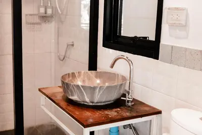 a bathroom with a bowl sink and a shower at Kunna House in Ko Yao Noi