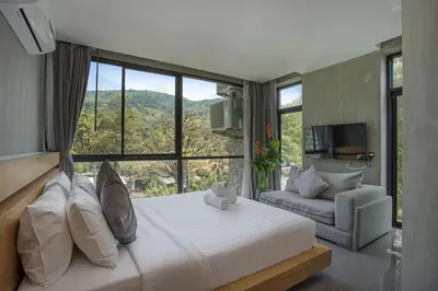 a bedroom with a bed and a large window at Villa Jeanne in Kamala Beach
