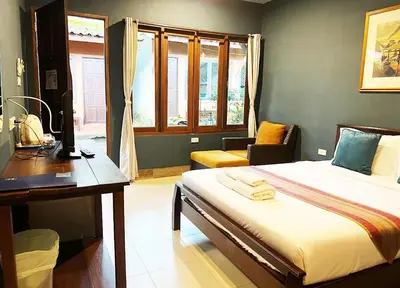 a hotel room with a bed and a desk and a desk at Phuket Siam Villas - SHA PLUS in Chalong