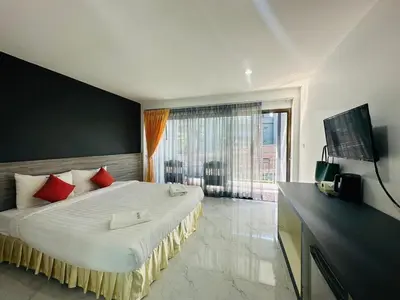 a bedroom with a large bed with red pillows at Machorat Aonang Resort at Aonang Beach Krabi in Ao Nang Beach