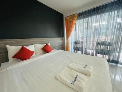 a bedroom with a large white bed with red pillows at Machorat Aonang Resort at Aonang Beach Krabi in Ao Nang Beach