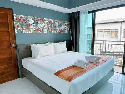 a bedroom with a bed with two towels on it at Machorat Aonang Resort at Aonang Beach Krabi in Ao Nang Beach
