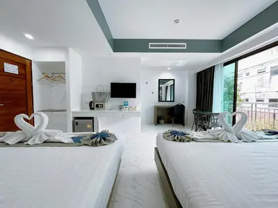 two beds in a hotel room with swans on them at Machorat Aonang Resort at Aonang Beach Krabi in Ao Nang Beach