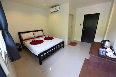 a bedroom with a bed with red flowers on it at Kitty Guesthouse in Phi Phi Don