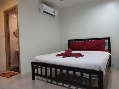 a bed with red pillows on it in a room at Kitty Guesthouse in Phi Phi Don
