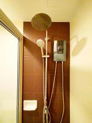 a shower in a bathroom with a shower head at Chic & Sweet, Pool view, Prime location near beach in Phuket Town