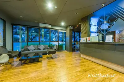 a lobby with a couch and chairs and windows at Chic & Sweet, Pool view, Prime location near beach in Phuket Town
