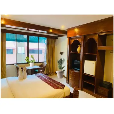 a bedroom with a bed and a desk and a window at Grillhütte Patong in Patong Beach