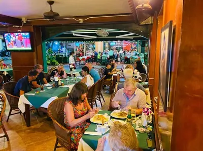 a group of people sitting at tables in a restaurant at Grillhütte Patong in Patong Beach