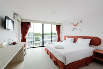 a hotel room with a bed and a large window at Moon Budget Hotel in Ao Nang Beach