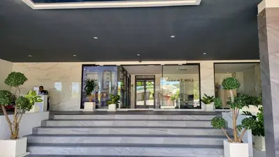 a lobby with stairs and potted plants in front of a building at VIP Great Hill Phuket Airport in Phuket Town