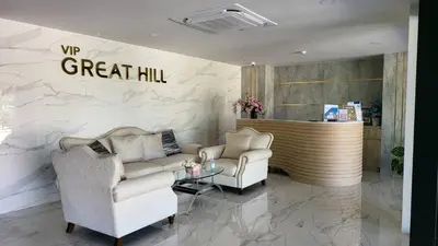 a lobby with two chairs and a table and a counter at VIP Great Hill Phuket Airport in Phuket Town