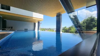 a swimming pool with a view of the water at VIP Great Hill Phuket Airport in Phuket Town