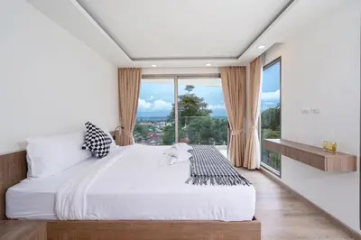 a bedroom with a large bed and a large window at seaview villa private swimming pool in Karon Beach
