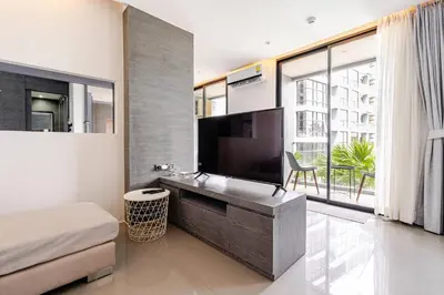 a bedroom with a large tv and a large window at CityGate by Villacarte in Kamala Beach