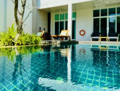 a swimming pool in front of a house at White Lotus by Oxygen at Bang Tao Beach in Ban Thalat Choeng Thale