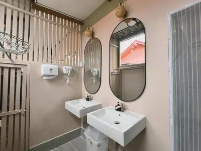 a bathroom with two sinks and two mirrors at The Snug Airportel - Phuket Airport in Nai Yang Beach
