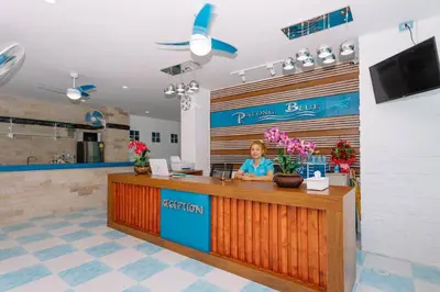 a woman sitting at a counter in a restaurant at PATONG BLUE HOTEL in Patong Beach