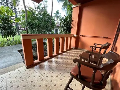 a rocking chair on the porch of a house at Phuket Leelavadee Hua Ting Resort in Patong Beach
