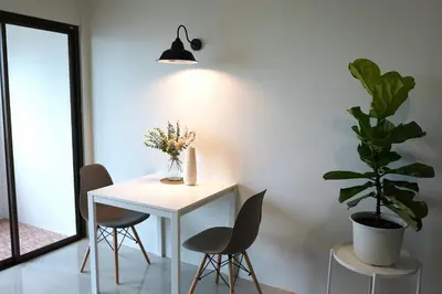 a white table with two chairs and a potted plant at Hommory Residence - West Chalong in Ban Klang