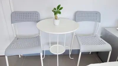 a white table and two chairs with a plant on it at Kata Bai D - SHA Certificate Hotel in Kata Beach