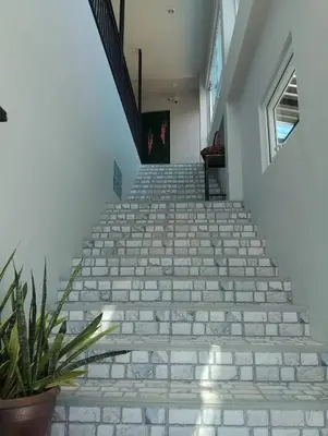 a staircase in a house with a potted plant at Triple J Hometel in Bang Tao Beach