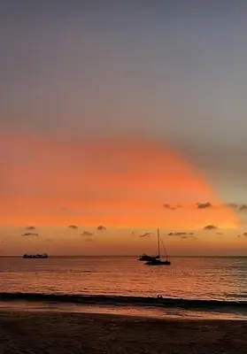 a sail boat on the beach at sunset at Triple J Hometel in Bang Tao Beach