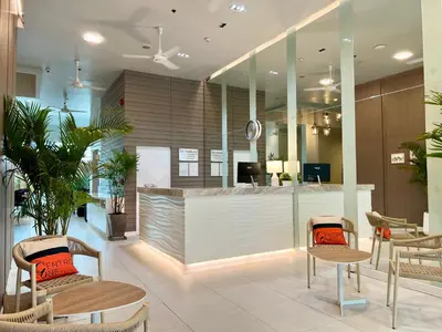 a lobby with chairs and a counter in a building at Centro One Patong in Patong Beach