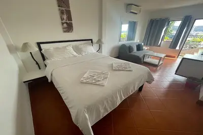 a bedroom with a bed with two towels on it at Swiss Villas Panoramic - Hillside Beach View in Patong Beach