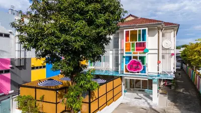 a colorful house with a tree in front of it at The Tint At Phuket Town - SHA Plus in Phuket Town