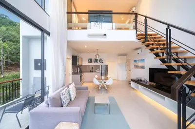 an open living room with a staircase and a living room at Deluxe apartment at Icon Park by Lofty in Kamala Beach