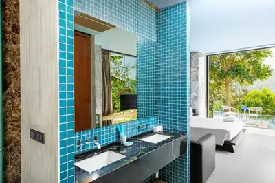 a blue tiled bathroom with two sinks and a mirror at Romantic villa in the tropics near Kamala Beach in Kamala Beach