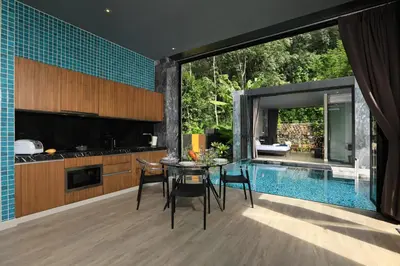 a kitchen and dining room with a table and a swimming pool at Seclusion in the mountains, villa near Kamala beach in Kamala Beach